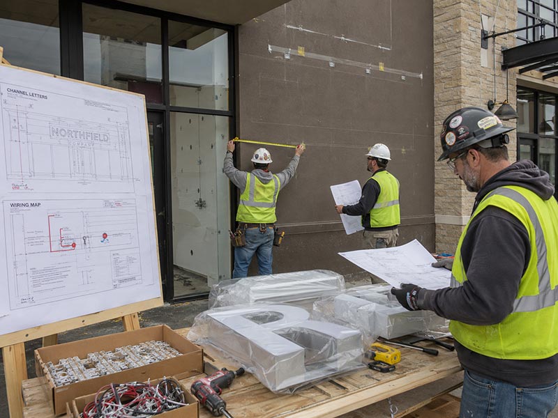 Construction contractor preparing installation for custom LED channel letters