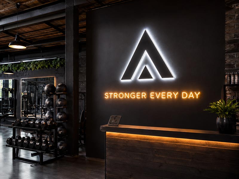 Gym and fitness studio using custom LED logo signs for interior branding