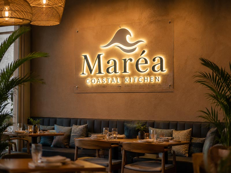 Custom LED neon restaurant logo sign on a warm interior wall