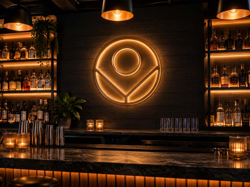 Custom illuminated wall logo sign installed inside a modern bar