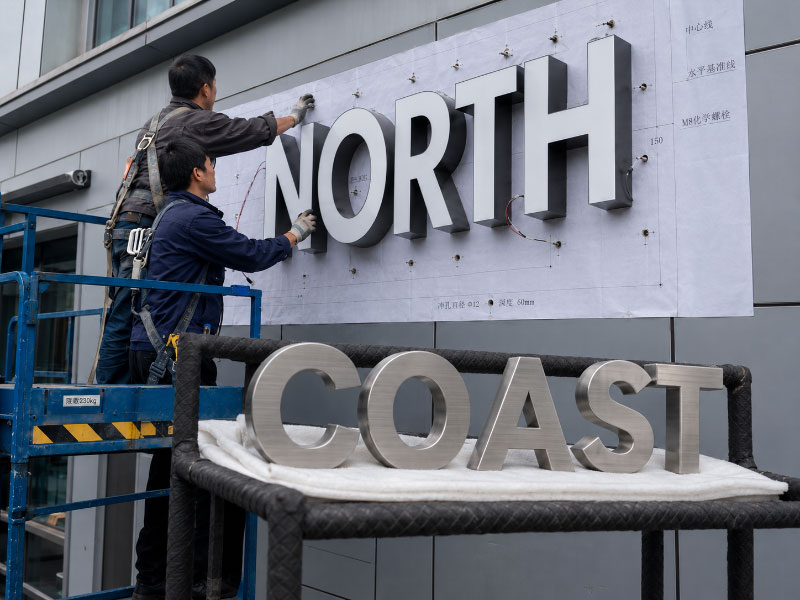 Installation of large aluminum channel letters with stainless steel letters prepared nearby
