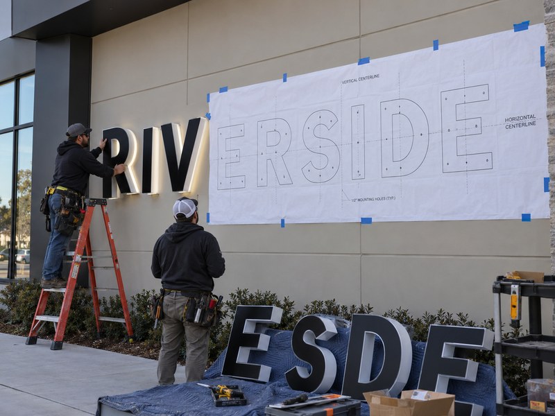 Full-size channel letter installation template used to position letters accurately on a storefront wall