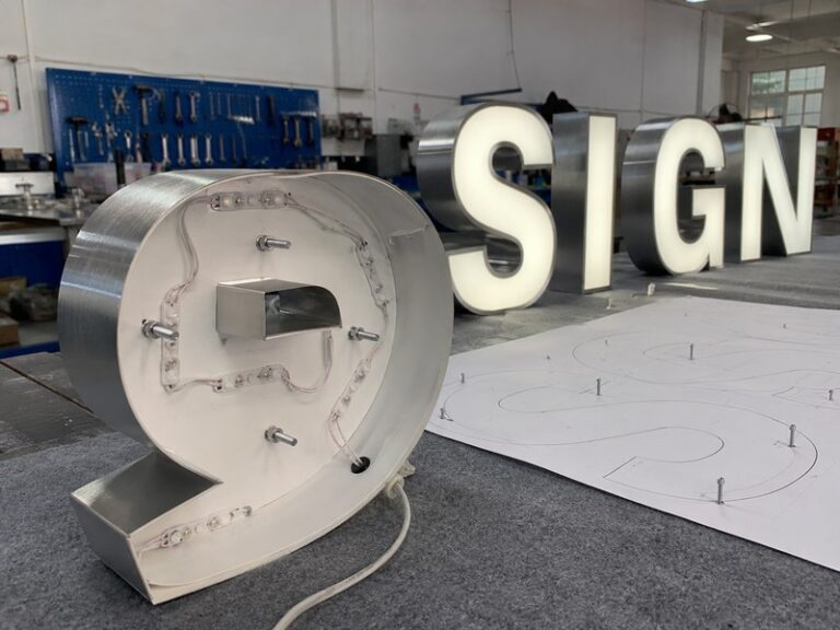 Channel letter mounting holes, threaded studs, wire exits, and installation template prepared before production
