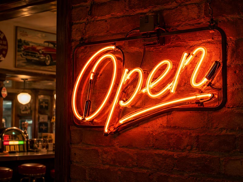 Glass neon sign installed on wall in bar showing warm glow