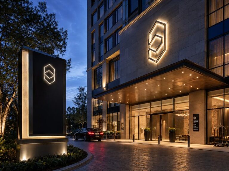 Custom hotel signage system with illuminated exterior signs, monument sign and interior wayfinding