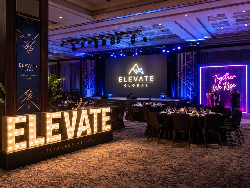 Different illuminated signs used for a corporate stage, photo wall, and event entrance