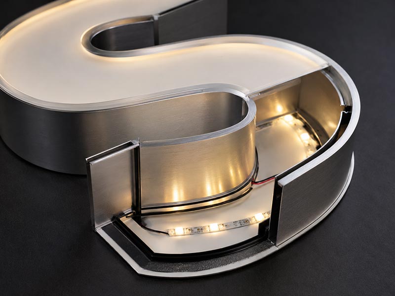 Close-up of LED channel letters showing acrylic face, aluminum return, and LED modules