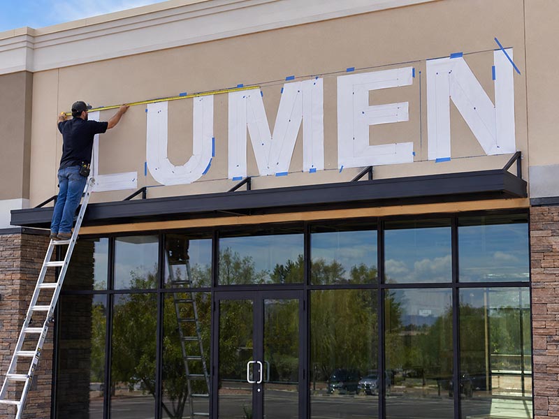 LED channel letters of varying heights mounted on storefront for size reference