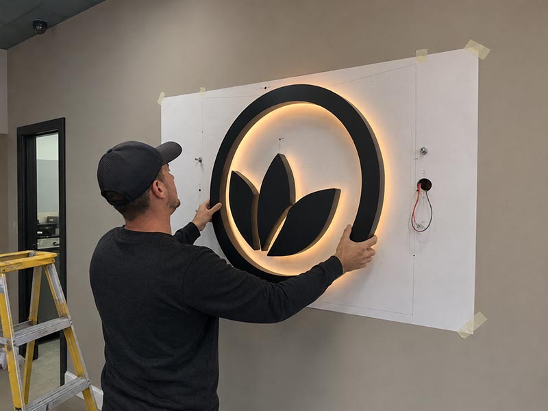 Custom LED sign installation showing mounting details, wire exit planning, and wall fitting requirements