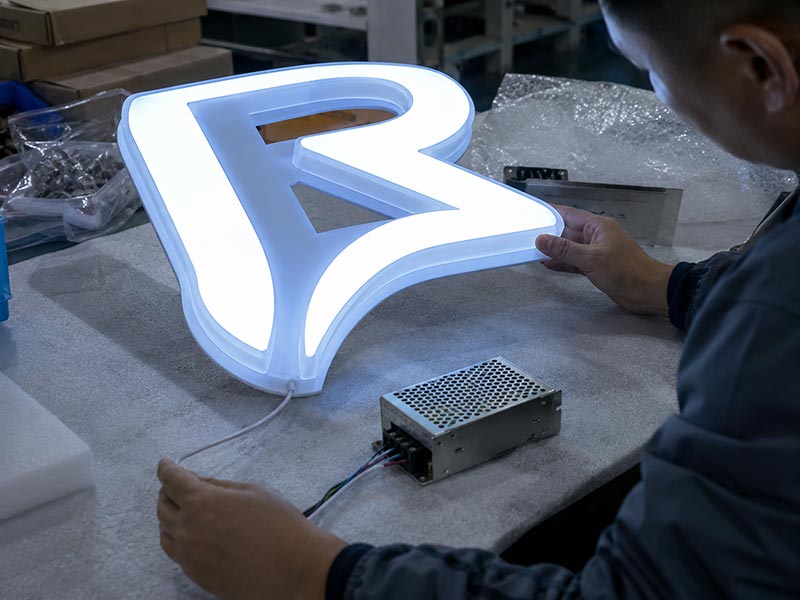 LED sign quality inspection checking lighting, wiring, acrylic finish, and power supply