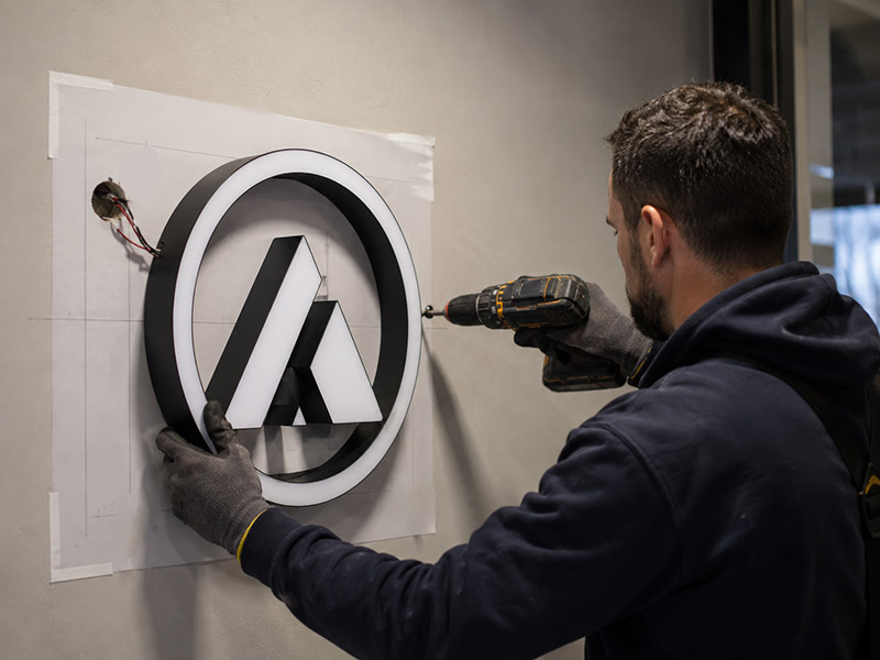 Wall-mounted LED sign installation showing mounting holes and wire exit details