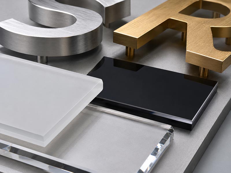 Close up of acrylic and metal materials for custom office logo signs