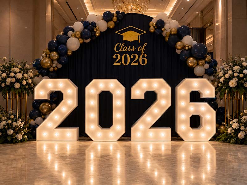 Large illuminated marquee numbers displayed at a graduation or milestone celebration