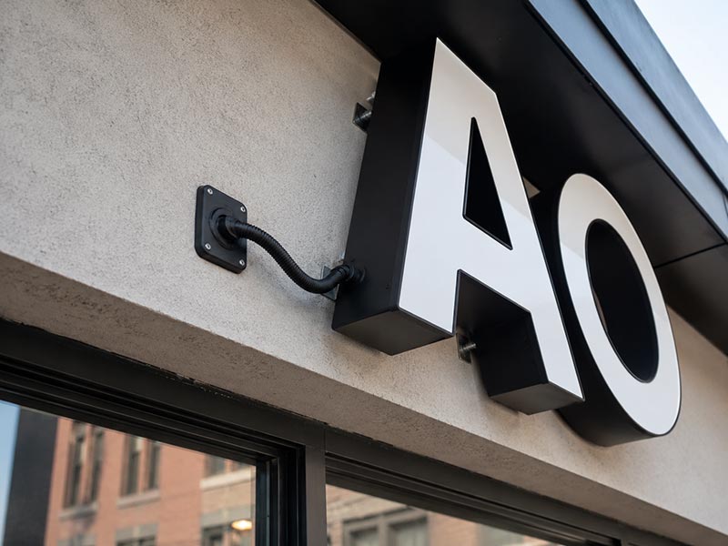 Outdoor LED sign installation detail with waterproof sealing, wall mounting points, and protected power cable routing