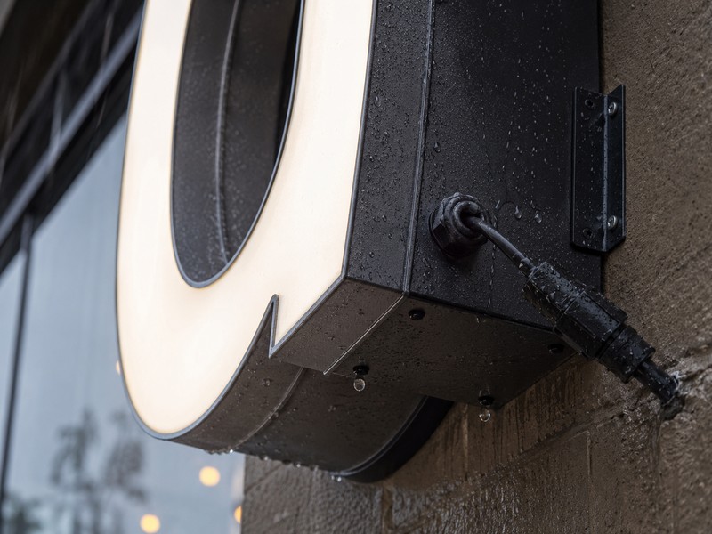 Outdoor illuminated sign with waterproof wiring sealing and drainage details