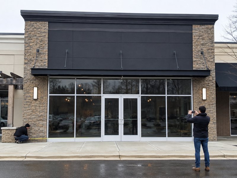 Full storefront photo showing the sign area and surrounding architectural details